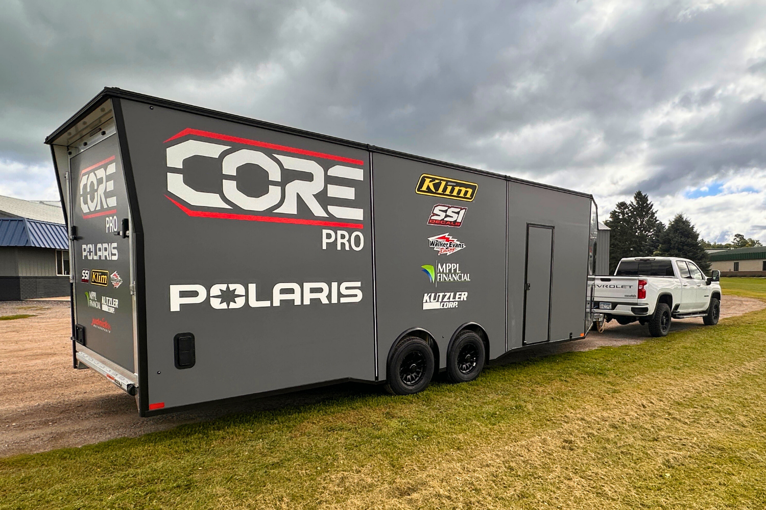 An interior look through from the back ramp door of an electrical contractor trailer, showing a lift inside the trailer with the interior components inside.